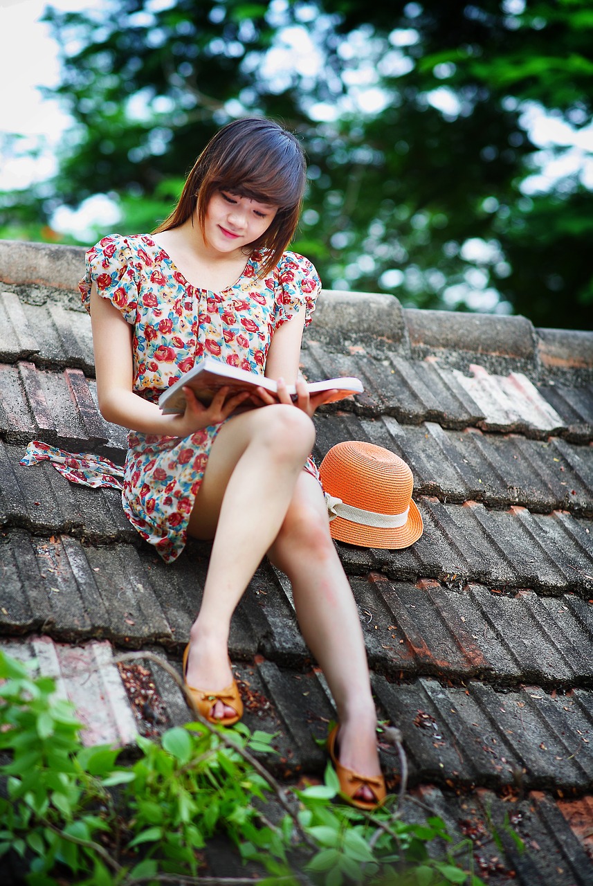 girl reading book to enhance her knowledge on a roof