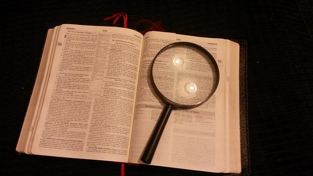 magnifying glass on top of holy bible for religious studies